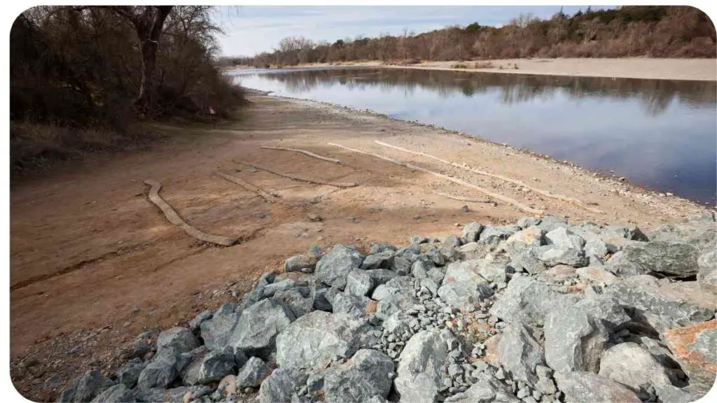 a river with rocks on the shore and water in the background